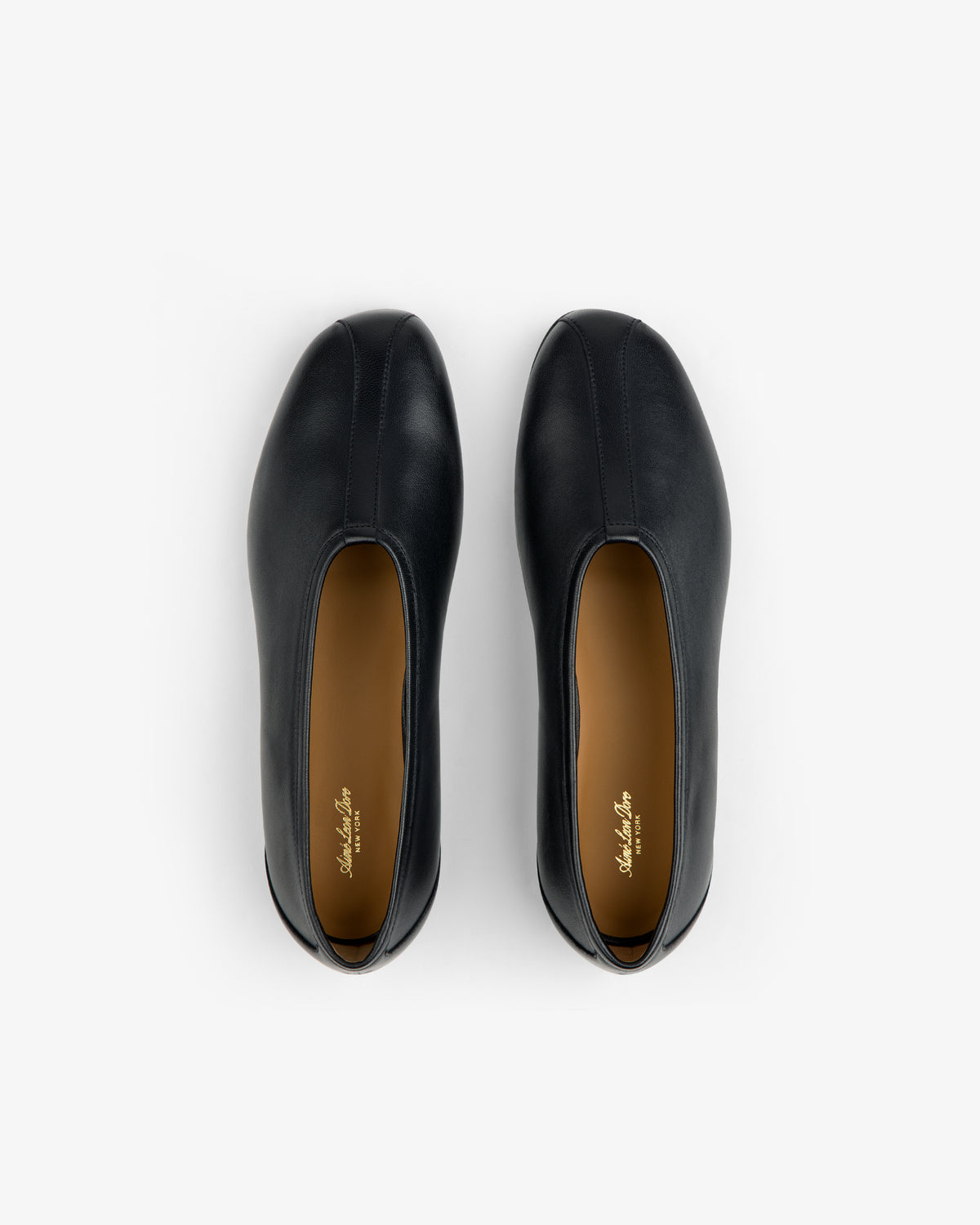 Top-down view of Leather Ballet Flat black shoes with tan insoles.