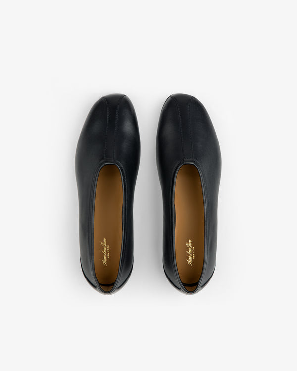 Top-down view of Leather Ballet Flat black shoes with tan insoles.