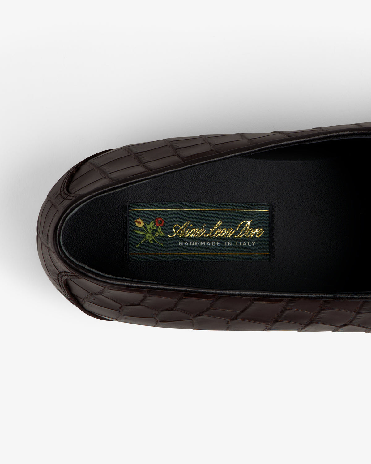 Brown croc-embossed Crest Salóni loafer with small floral detail, labeled Sidonie Larizzi, Handmade in Italy.
