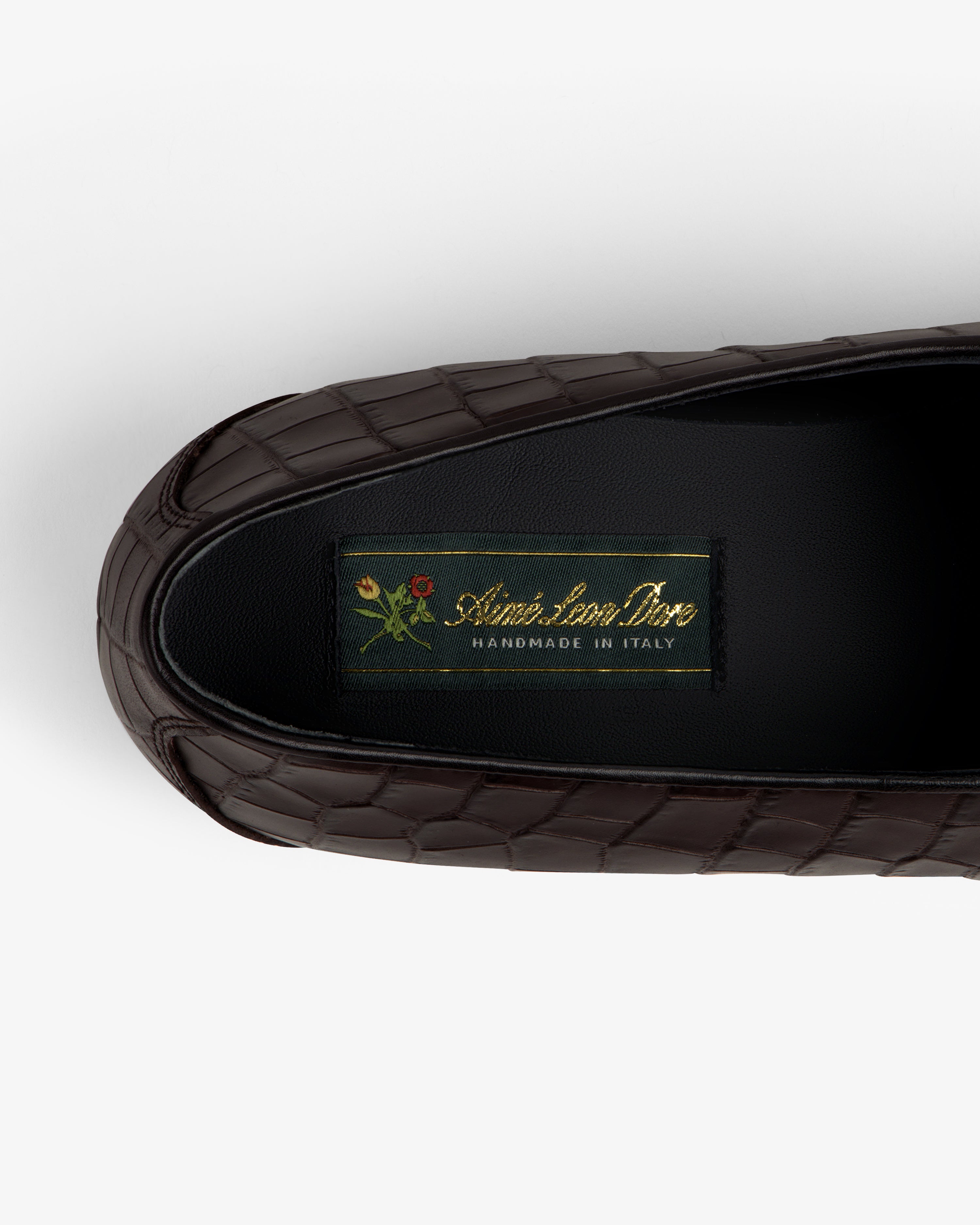 Brown croc-embossed Crest Salóni loafer with small floral detail, labeled Sidonie Larizzi, Handmade in Italy.