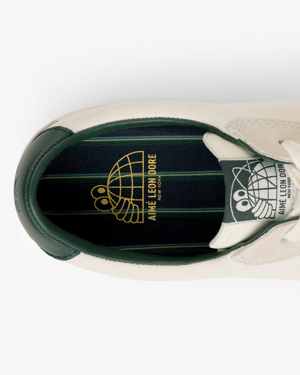 Top view of ALD / Last Resort AB VM001-LO Canvas sneaker with green/gold line art insole and Aimé Leon Dore text.