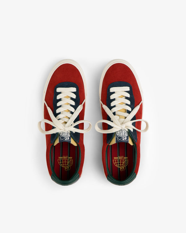 ALD / Last Resort AB VM001-LO Suede red sneakers with white laces, navy and green accents, top view on white background.