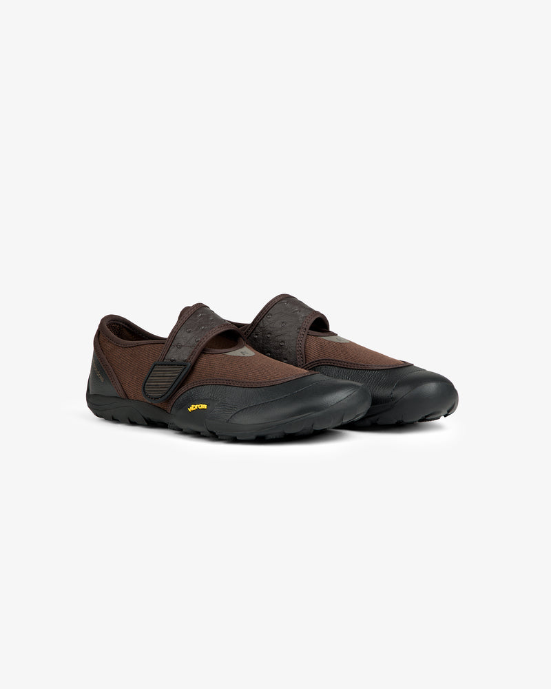 ALD / New Balance MT2 brown and black slip-on trail shoes with a strap closure and a lugged rubber sole.
