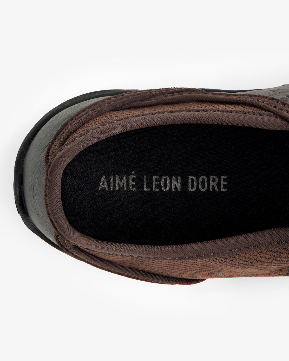Top-down view of an ALD / New Balance MT2 brown slip-on shoe with AIMÉ LEON DORE printed on the black insole.