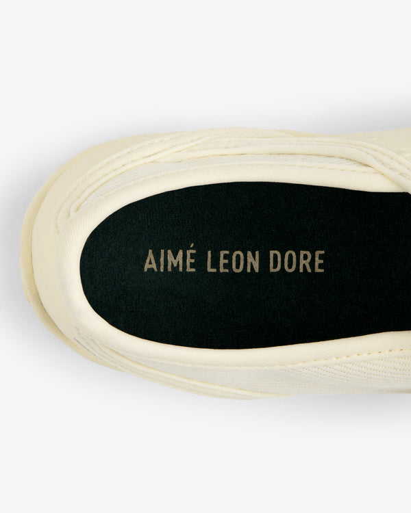 Top-down view of an ALD / New Balance MT2 sneaker interior with a black insole featuring the brand name in gold lettering.