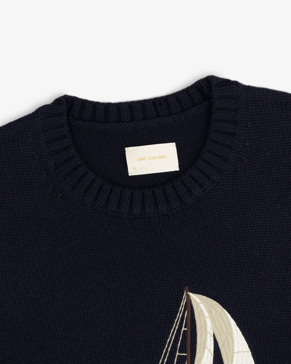 Regatta Embroidered Crewneck Sweater in navy with ribbed collar and partial sailboat embroidery at lower right.