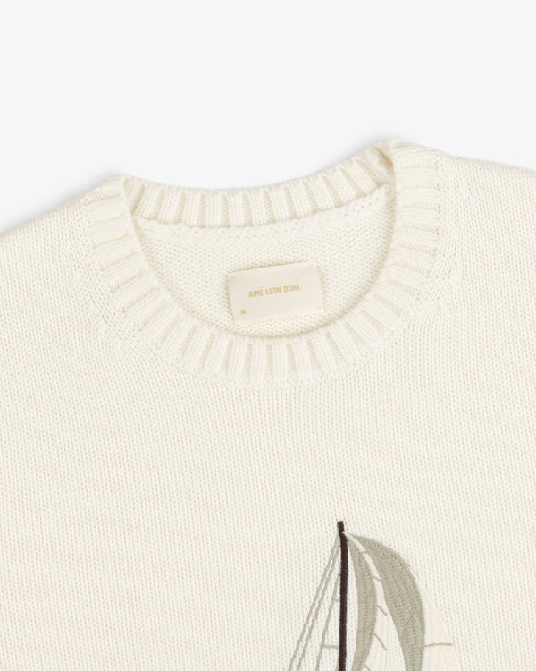 Regatta Embroidered Crewneck Sweater in cream knit with ribbed neckline and partial sailboat embroidery by Aimé Leon Dore.