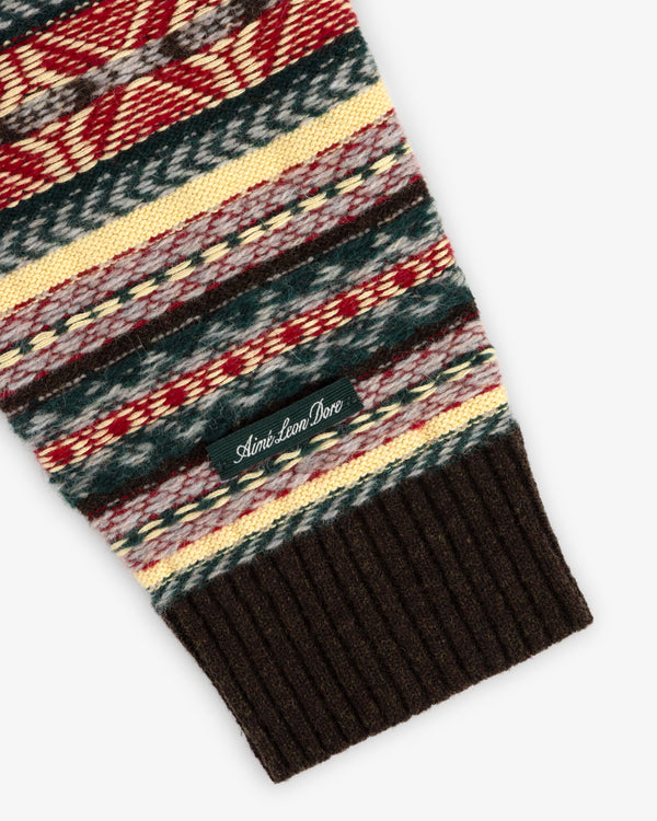 Fair Isle V-Neck Sweater sleeve features multicolor patterns, ribbed brown cuff, and a small Aimé Leon Dore tag.