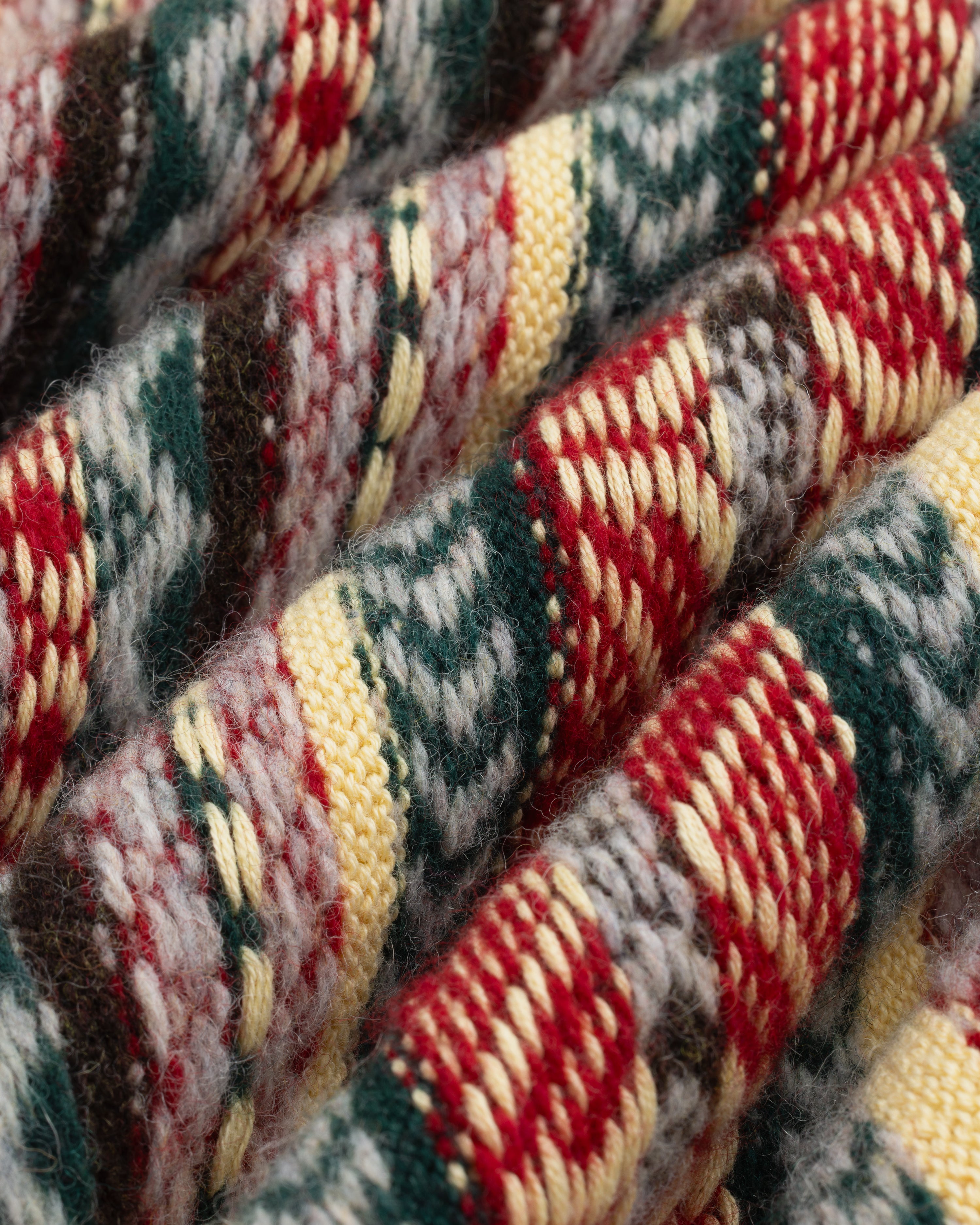 Close-up of Fair Isle V-Neck Sweater featuring colorful, textured knit with red, yellow, gray, and green stripes.