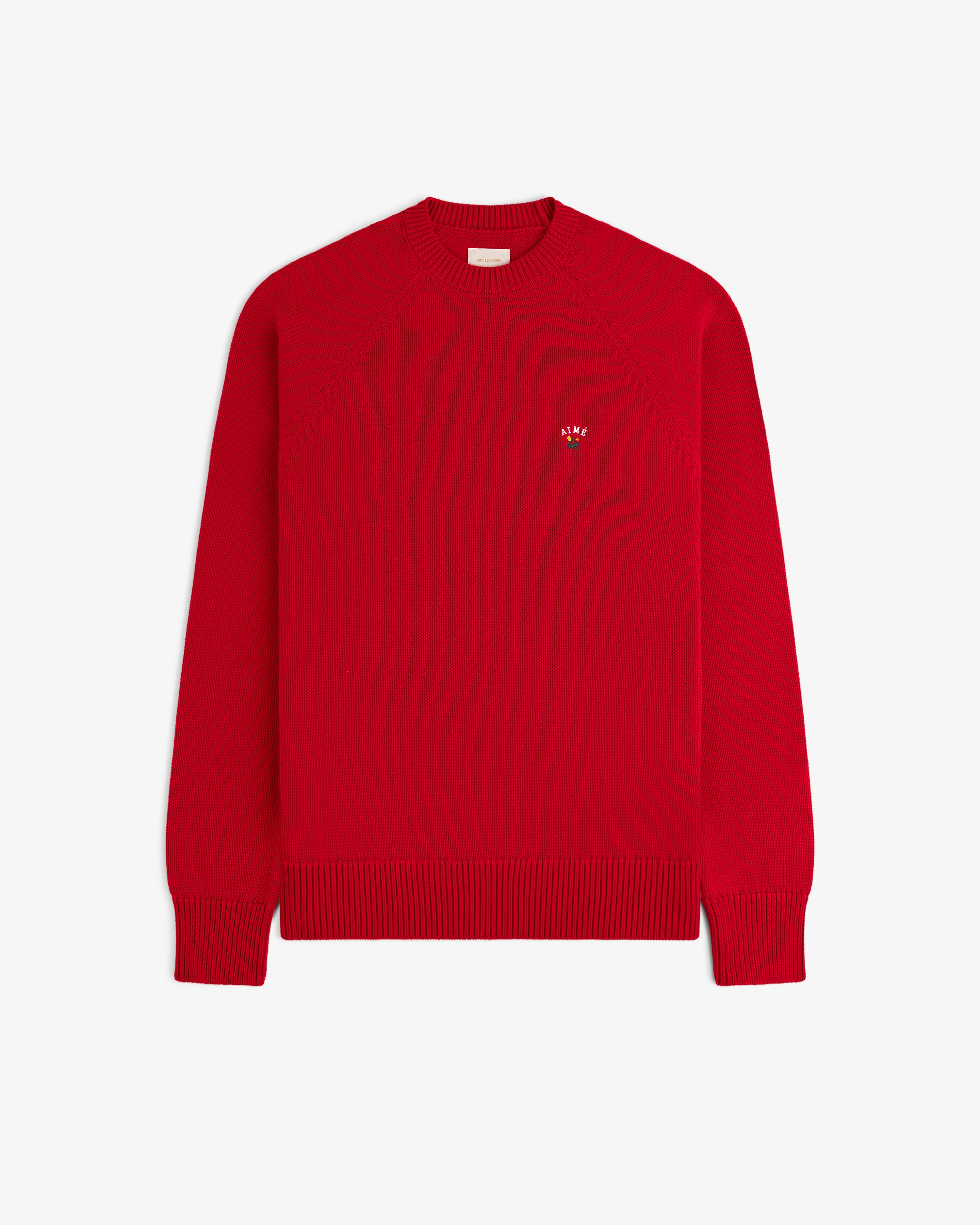 Crest Raglan Sweater: Bright red, long-sleeve knit with ribbed cuffs, hem, and a small left-chest logo.