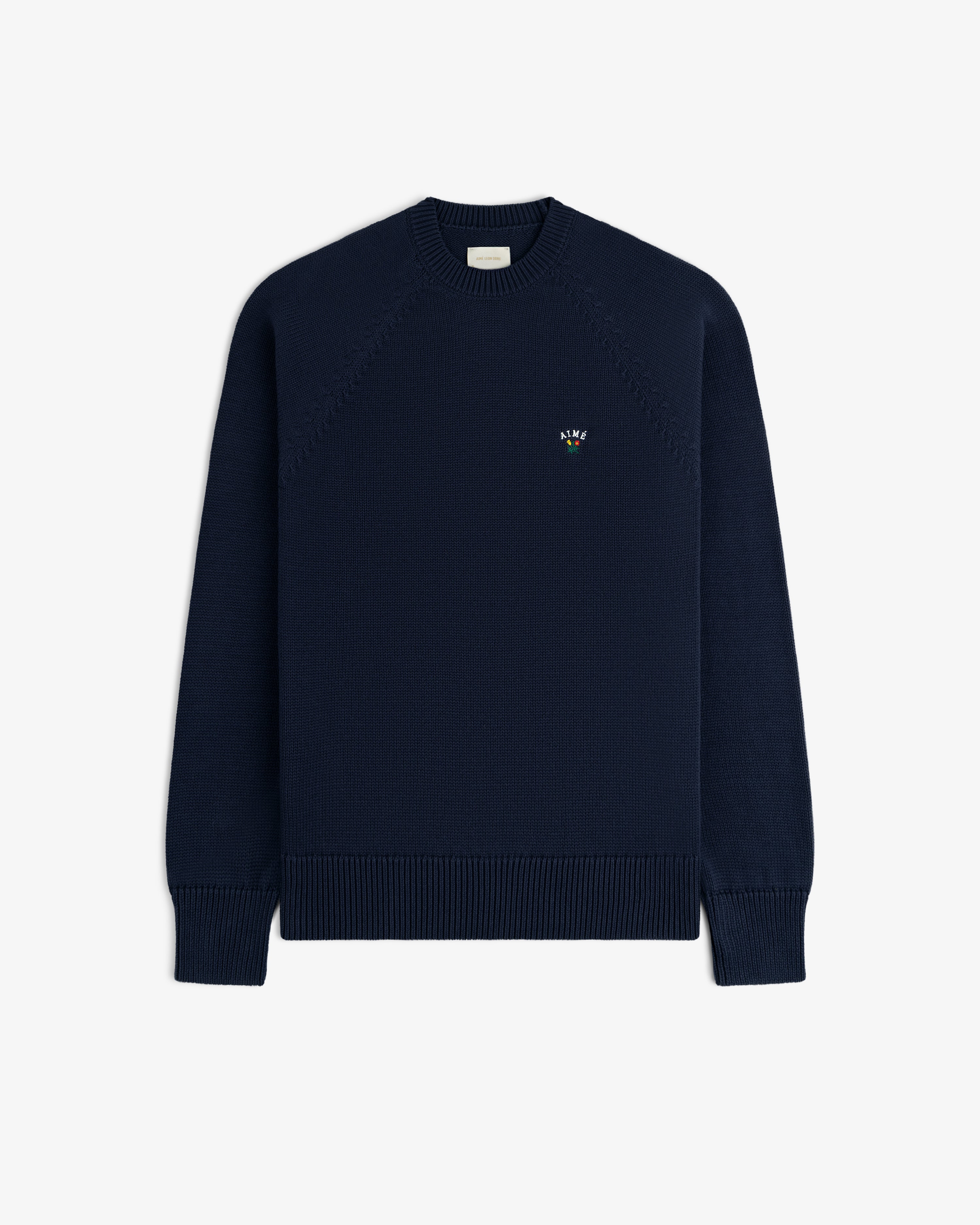 Crest Raglan Sweater: navy crewneck with ribbed cuffs, hem, and an embroidered logo on the left chest.