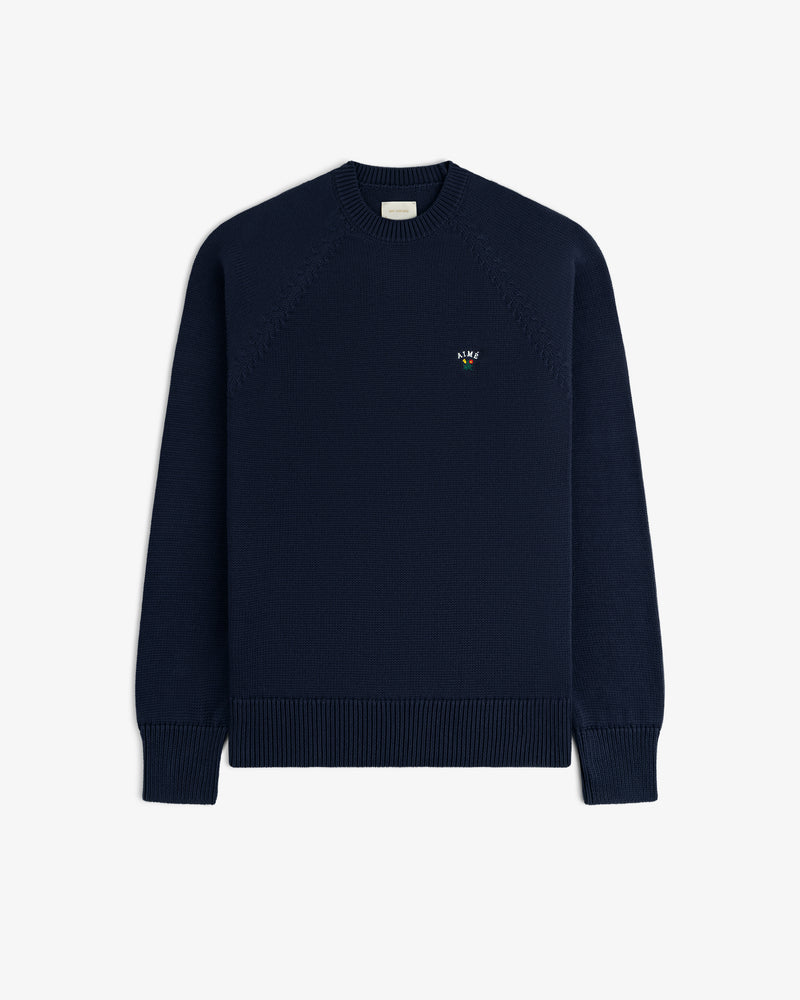 Crest Raglan Sweater: navy crewneck with ribbed cuffs, hem, and an embroidered logo on the left chest.