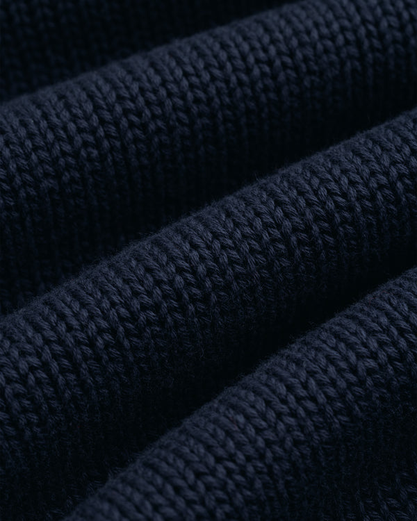 Close-up of the Crest Raglan Sweater’s dark blue ribbed knit, featuring soft horizontal ridges and even stitching.