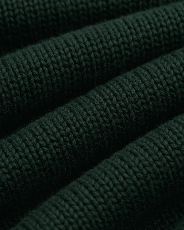 Close-up of Crest Raglan Sweater in dark green with horizontal ribbed texture and plush, thick yarn.
