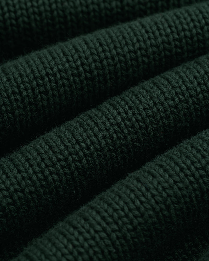Close-up of Crest Raglan Sweater in dark green with horizontal ribbed texture and plush, thick yarn.