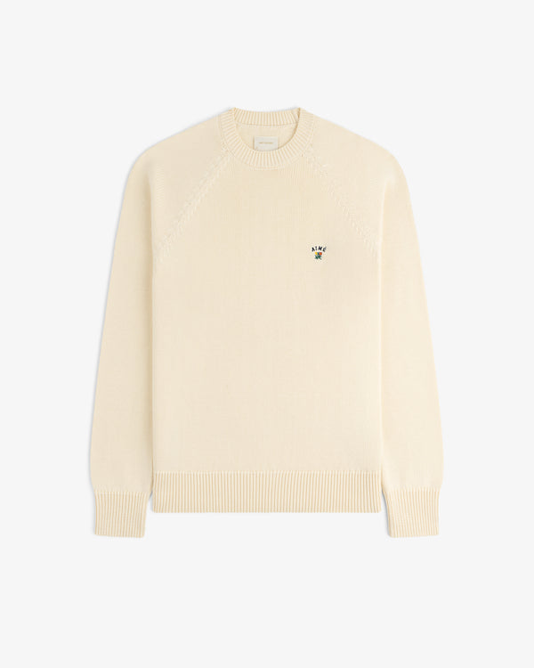 Crest Raglan Sweater in cream, long sleeves, small chest logo, displayed flat on a white background.