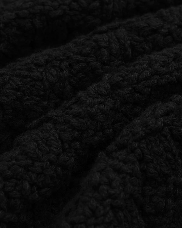 Close-up of a Checkerboard Bouclé Sweater in black textured knit with a subtle checkerboard pattern.