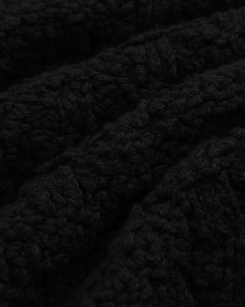 Close-up of a Checkerboard Bouclé Sweater in black textured knit with a subtle checkerboard pattern.
