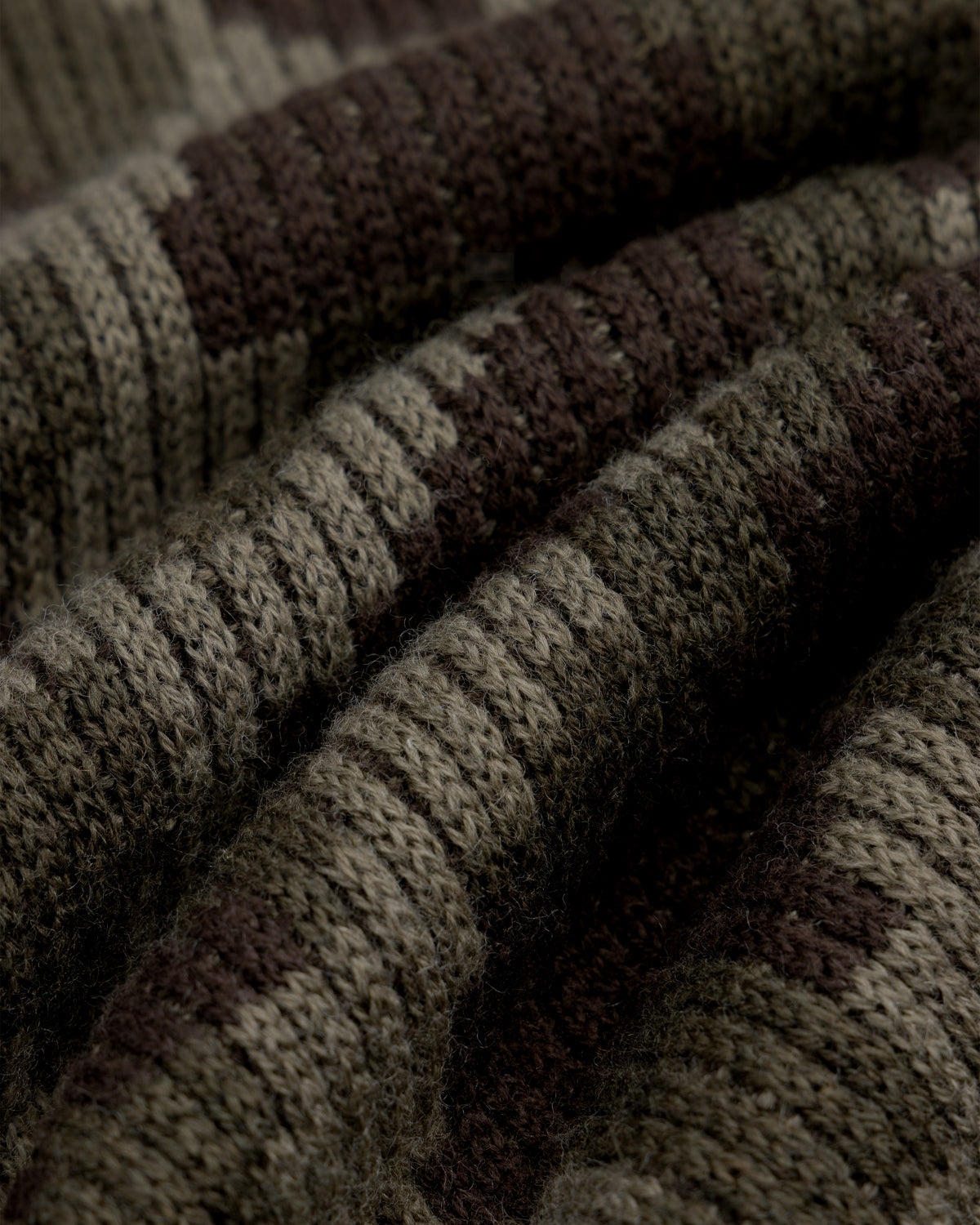 Close-up of a Wool Jacquard Camo Sweater in a ribbed knit with a dark green and brown camouflage pattern.