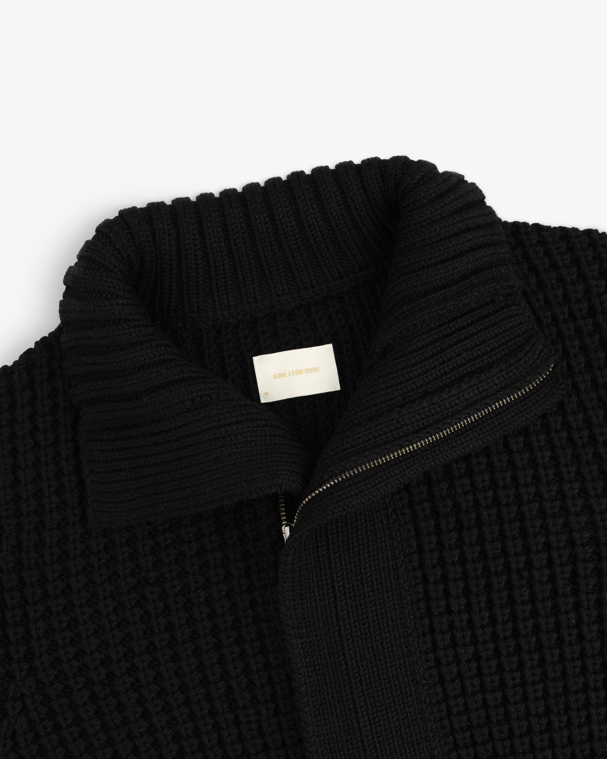Black Merino Wool Full Zip Sweater with a high ribbed collar and brand label at the neck.