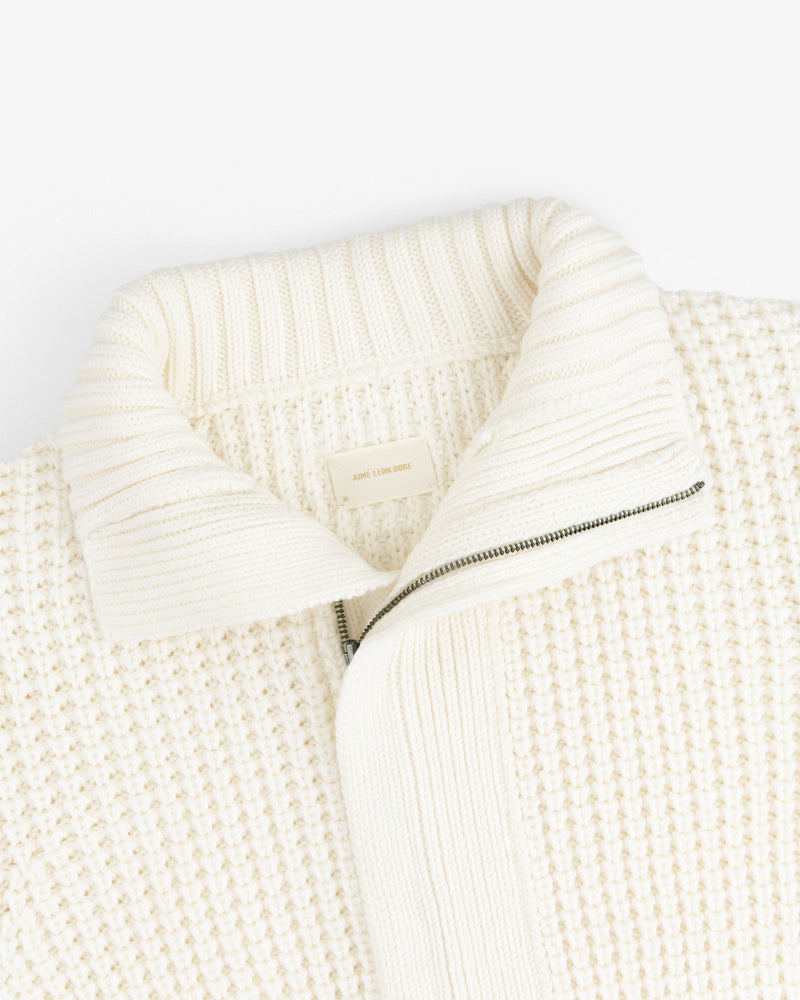 Cream-colored Merino Wool Full Zip Sweater with a ribbed collar and a partial zipper.