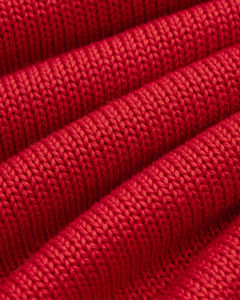 Close-up of red knit fabric with diagonal ridges on a Knit Pocket Crewneck Sweater.