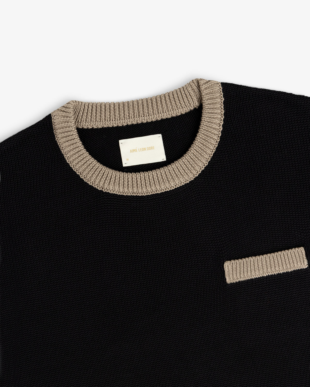 Knit Pocket Crewneck Sweater in black with a contrasting tan ribbed collar and chest pocket.
