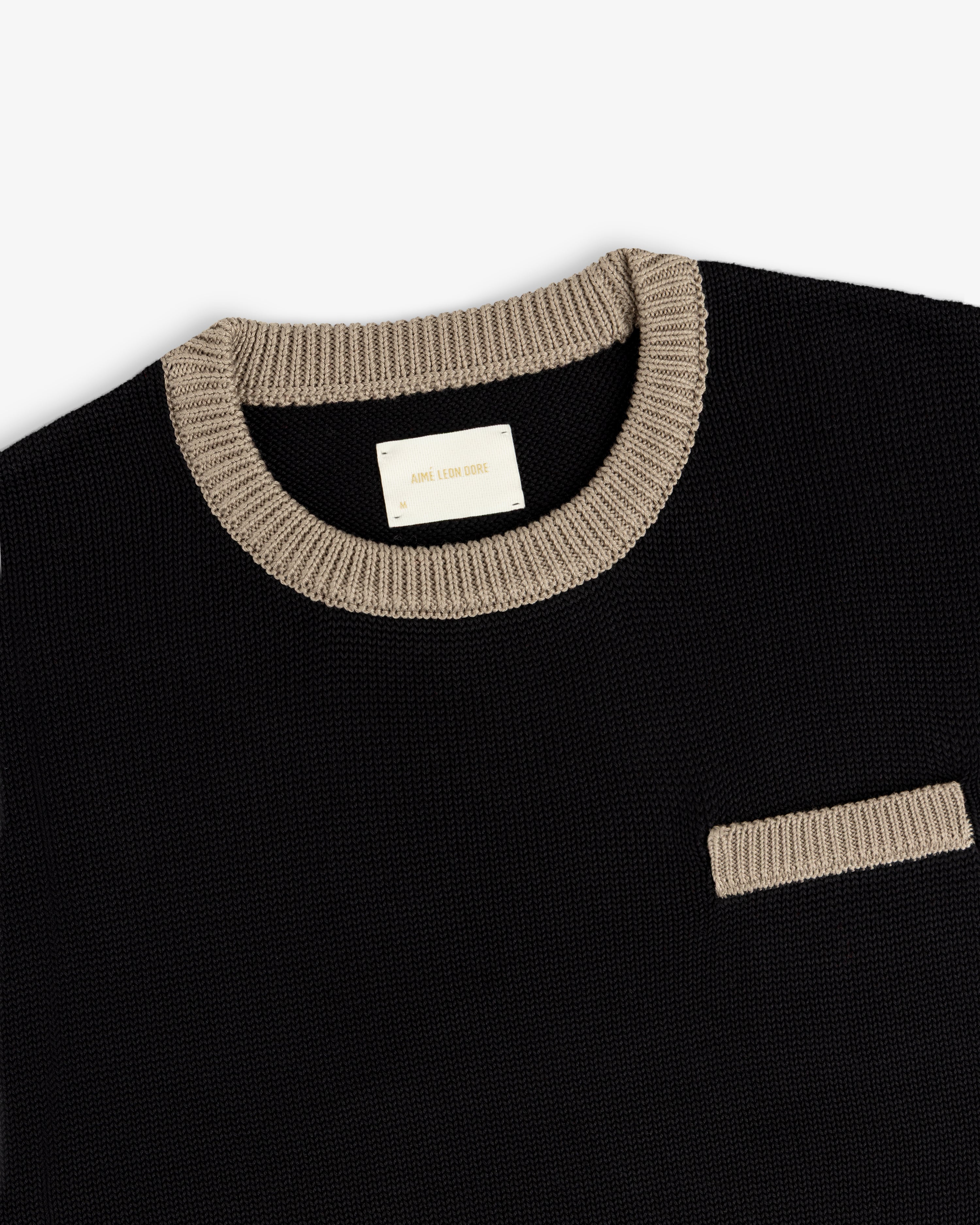 Knit Pocket Crewneck Sweater in black with a contrasting tan ribbed collar and chest pocket.