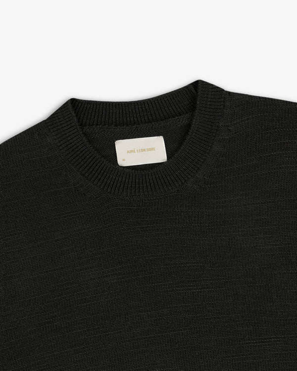 Black Slub Merino Wool sweater with a ribbed crewneck collar and a branded neck label.