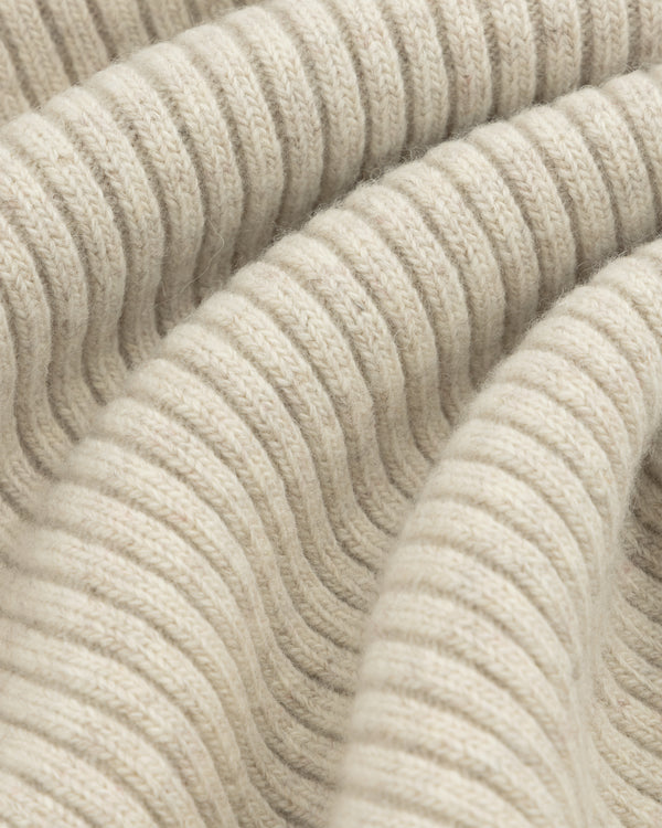 Close-up of beige Wool Ribbed Knit Hoodie fabric with soft folds.