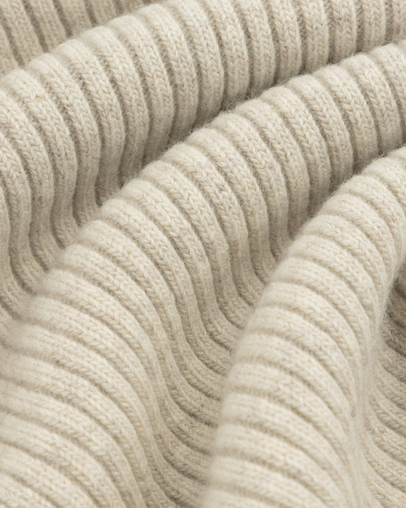 Close-up of beige Wool Ribbed Knit Hoodie fabric with soft folds.