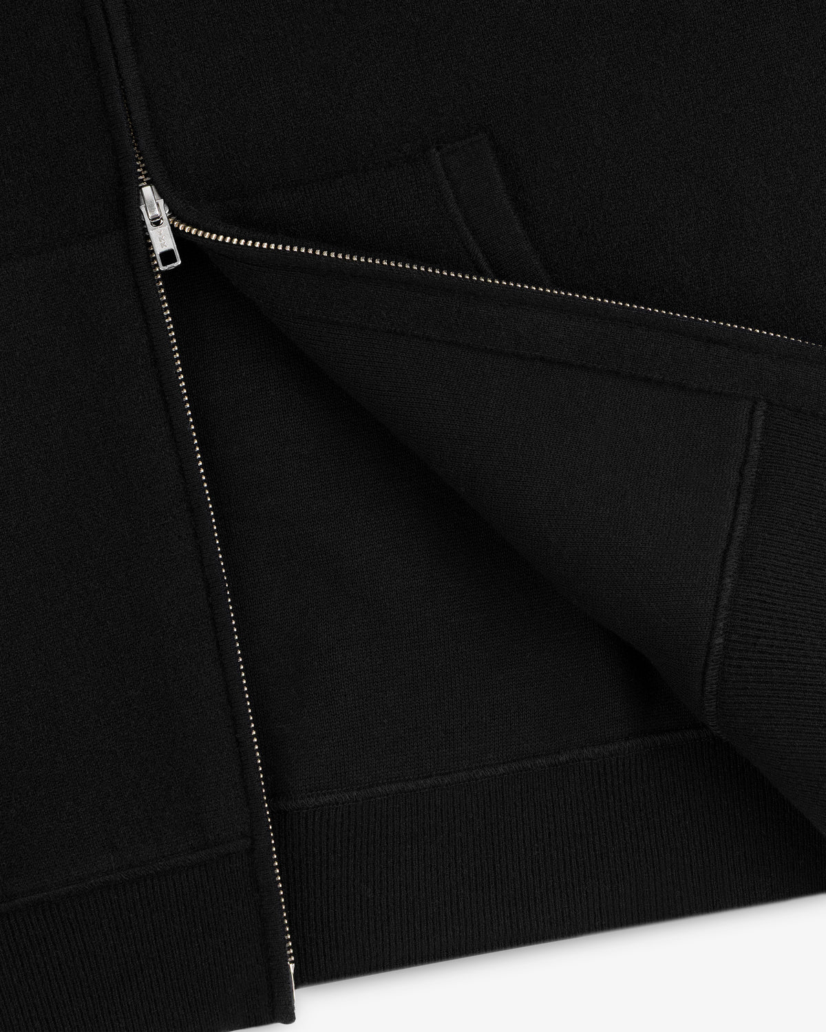 Close-up of a partially unzipped Full-Zip Pavilion Cashmere Hoodie, highlighting the hem and pocket seams.
