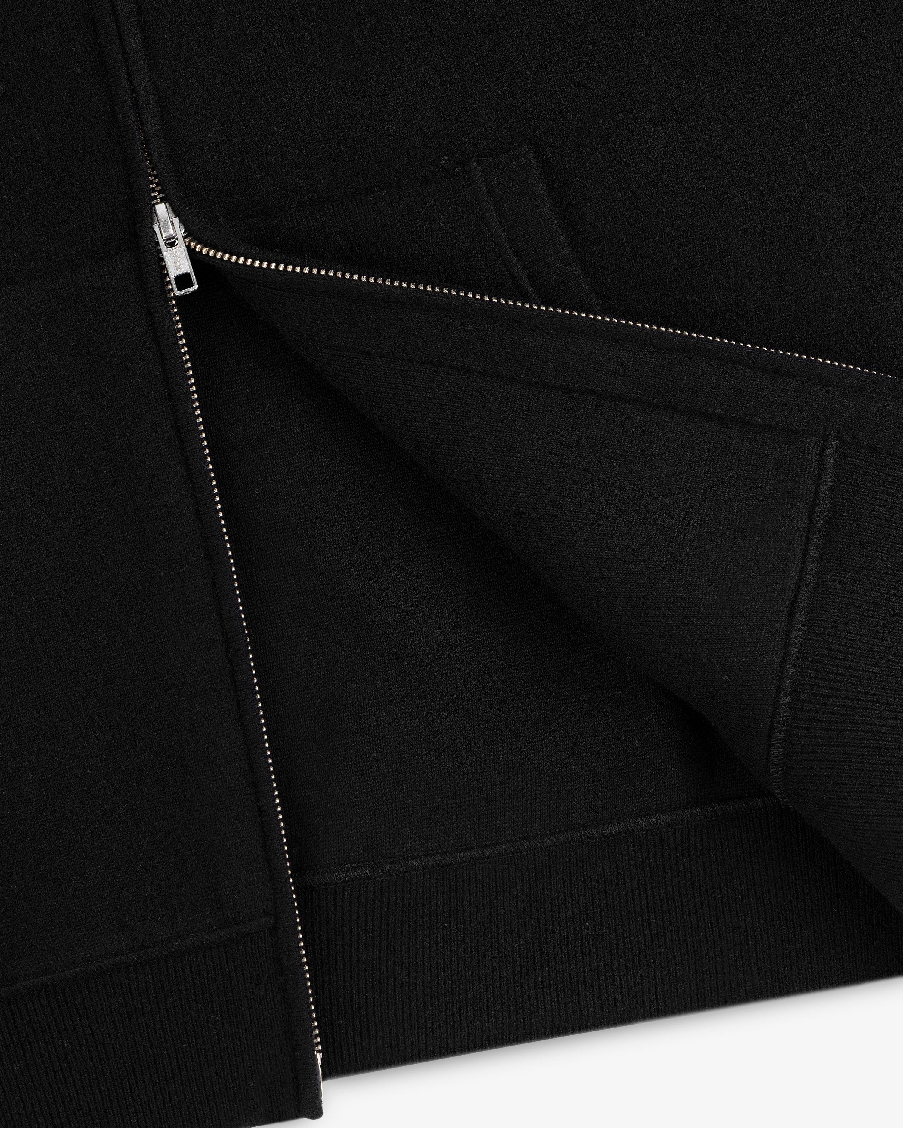 Close-up of a partially unzipped Full-Zip Pavilion Cashmere Hoodie, highlighting the hem and pocket seams.