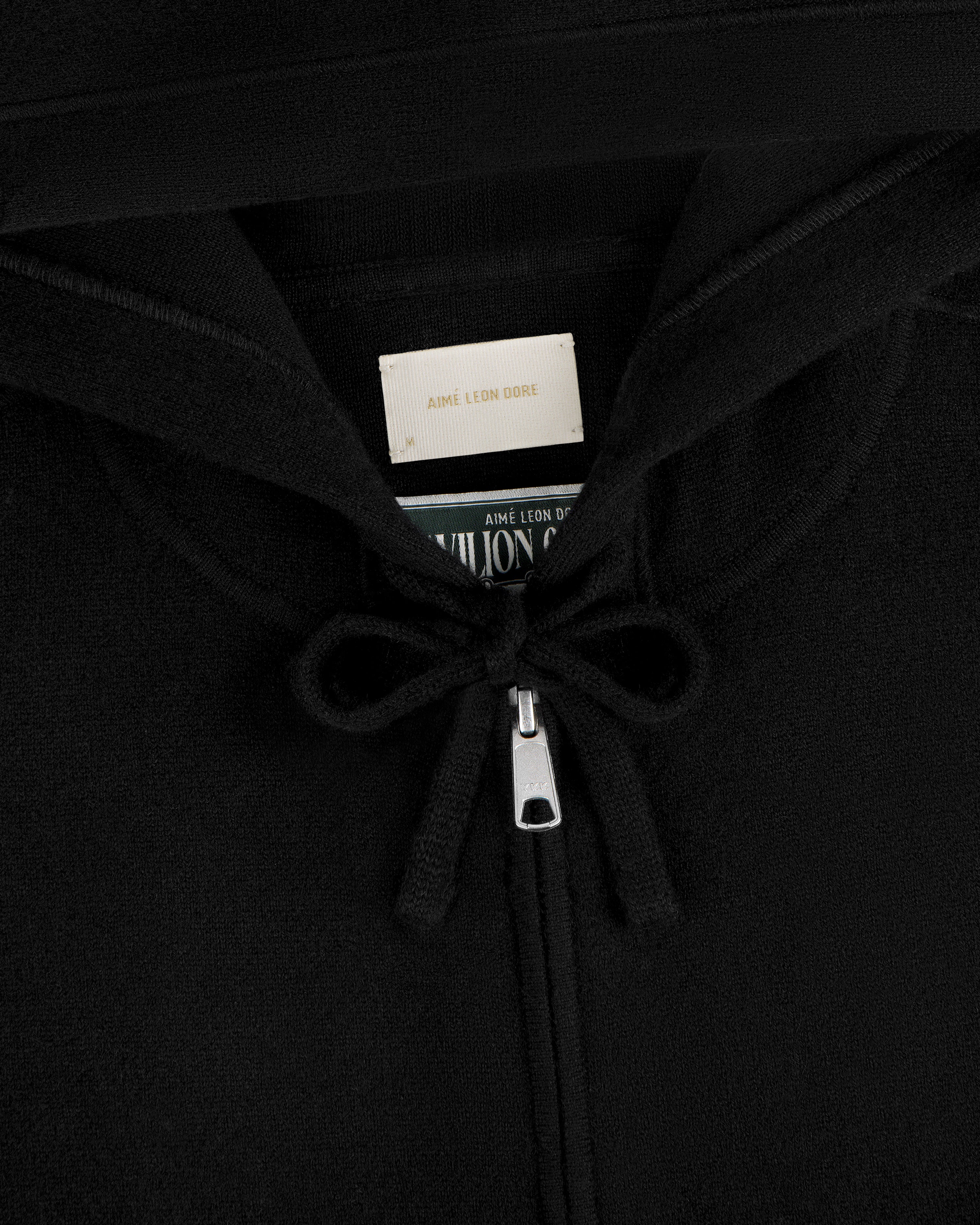 Close-up of Full-Zip Pavilion Cashmere Hoodie zipper with tied strings and label inside the collar.