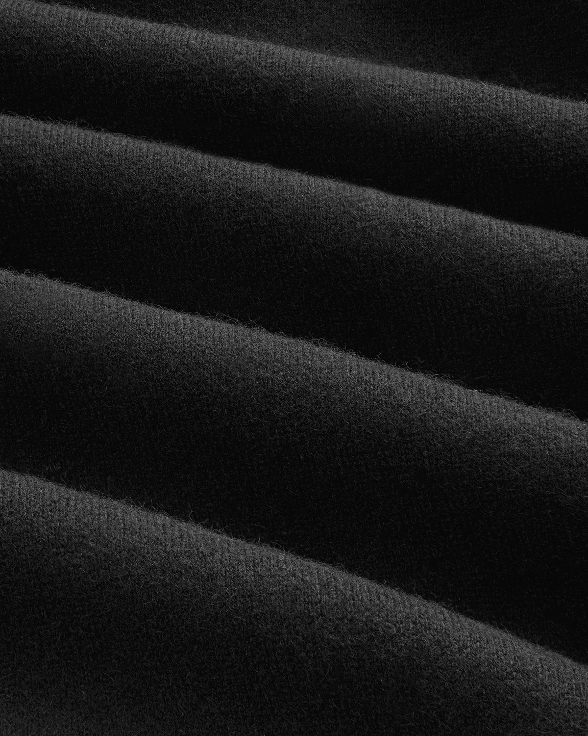Close-up of Pavilion Cashmere Sweatpant in black, showing ribbed fabric with soft, parallel textured ridges.