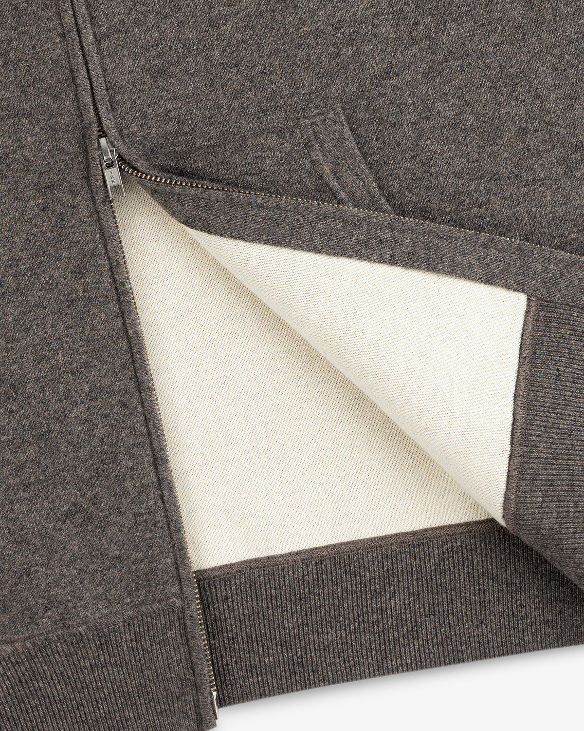 A close-up of the Full-Zip Pavilion Cashmere Hoodie, highlighting its off-white lining and ribbed hem.