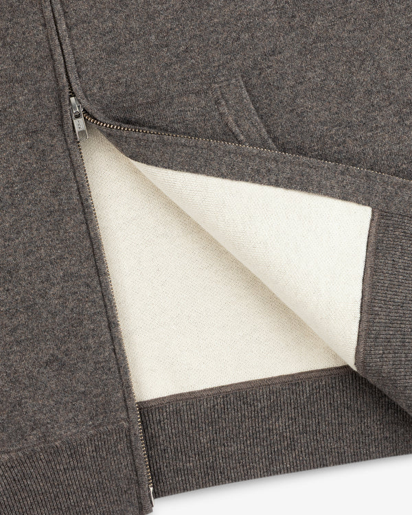 A close-up of the Full-Zip Pavilion Cashmere Hoodie, highlighting its off-white lining and ribbed hem.