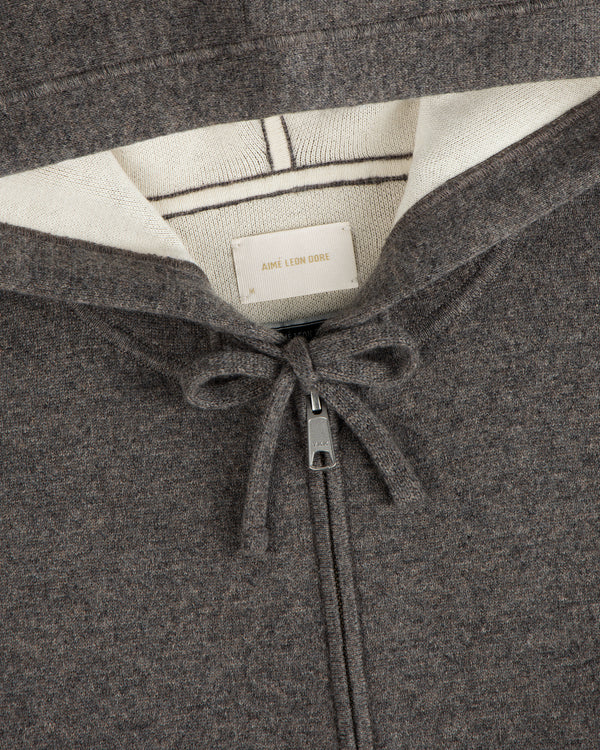 Close-up of the Full-Zip Pavilion Cashmere Hoodie in brown with cream lining, drawstring, and Aimé Leon Dore label.
