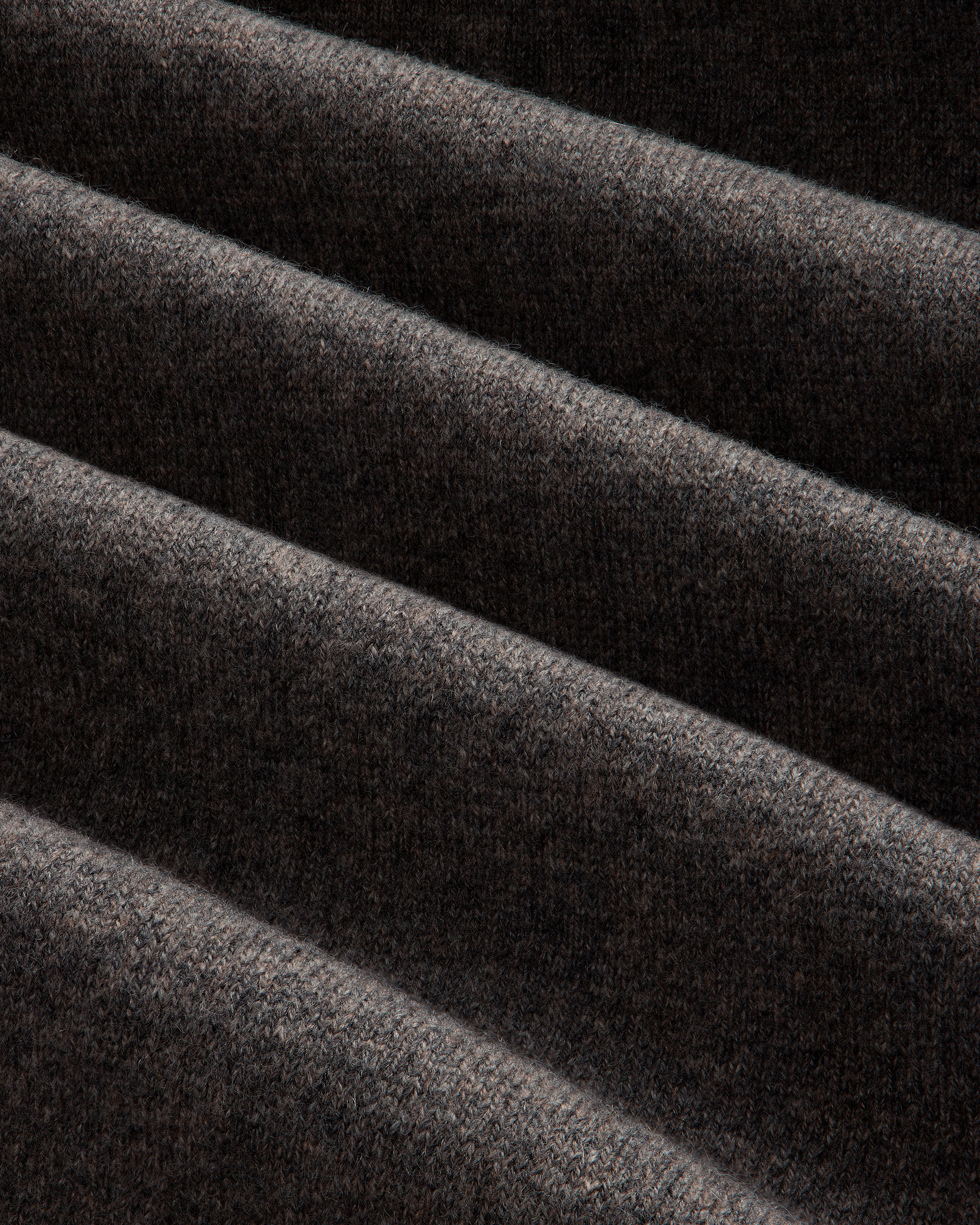 Close-up of Pavilion Cashmere Sweatpant in dark brown ribbed fabric, with soft folds and textured highlights.