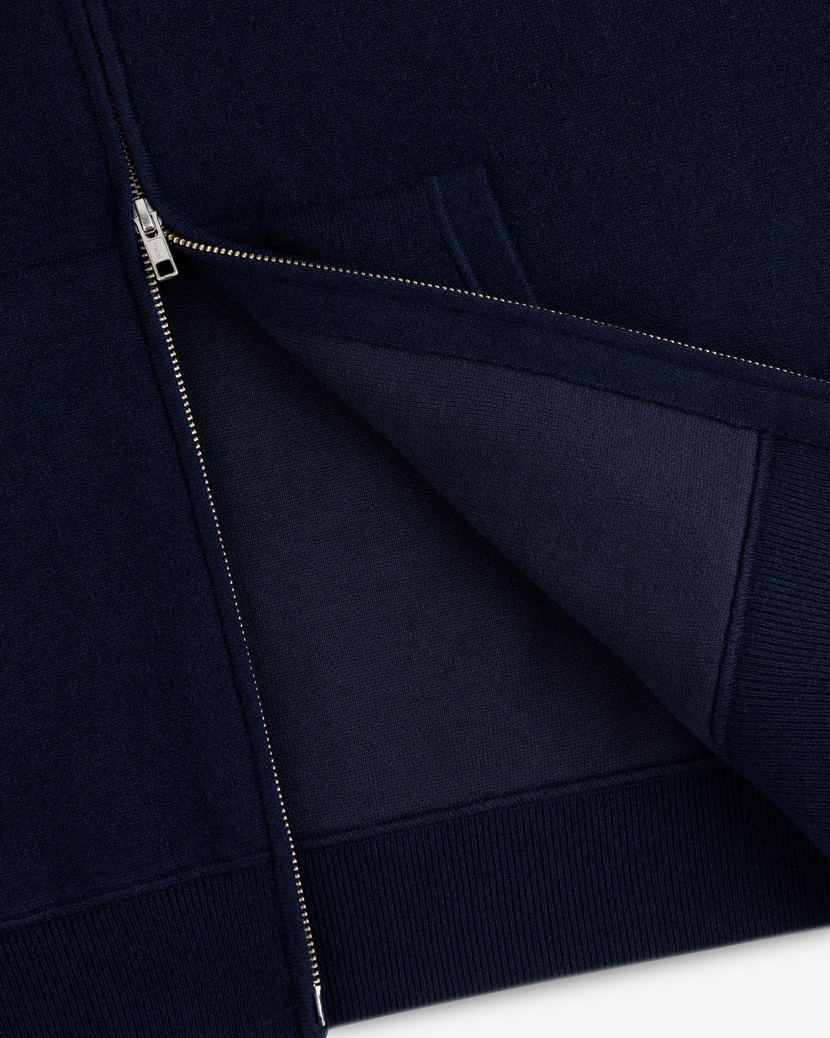 Close-up of the Full-Zip Pavilion Cashmere Hoodie in navy with a silver zipper, showing the inner fabric.