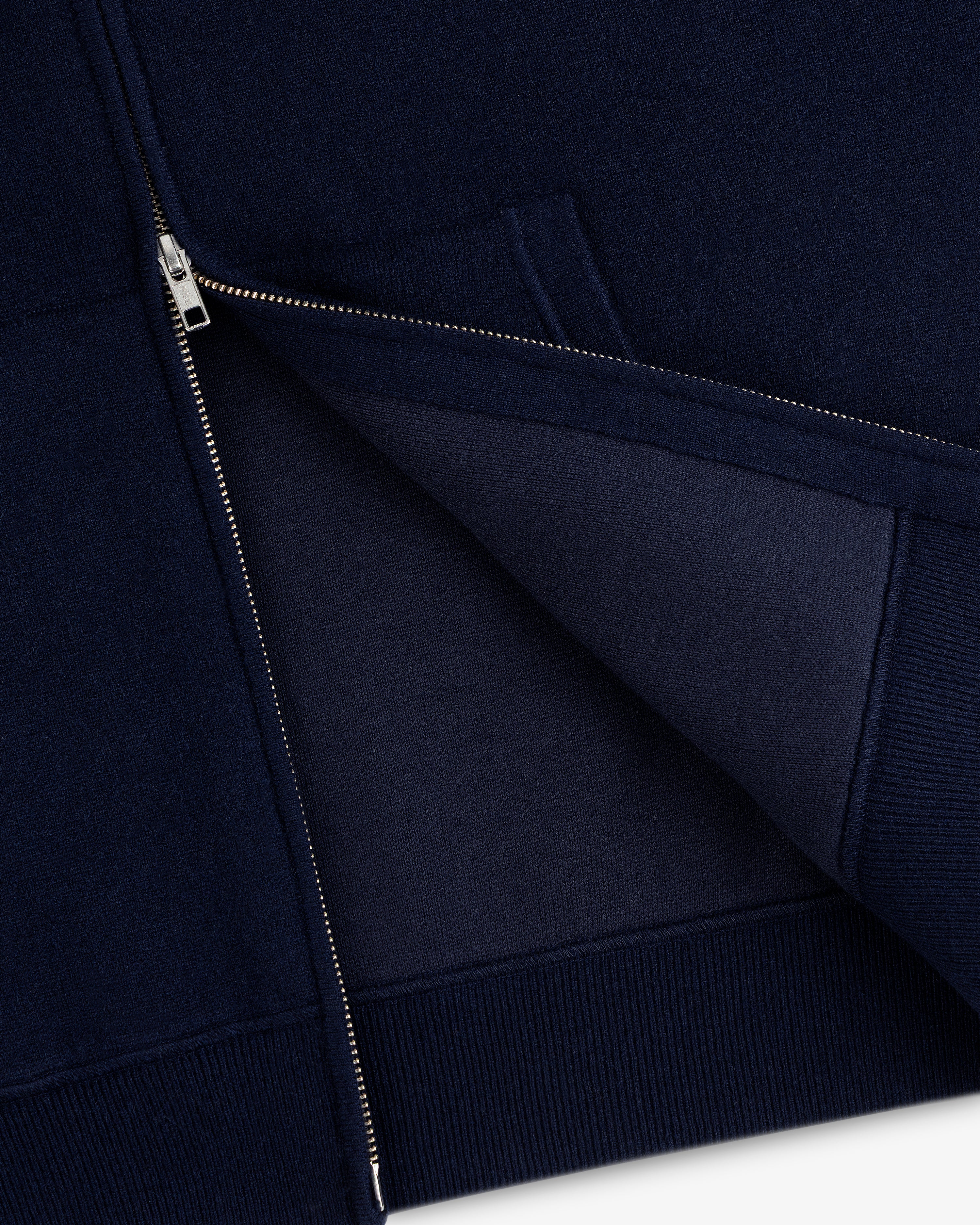 Close-up of the Full-Zip Pavilion Cashmere Hoodie in navy with a silver zipper, showing the inner fabric.