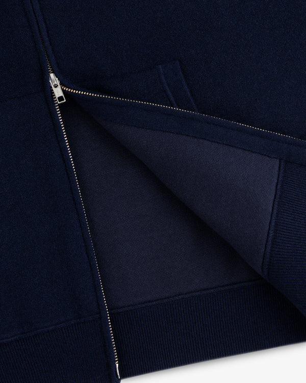 Close-up of the Full-Zip Pavilion Cashmere Hoodie in navy with a silver zipper, showing the inner fabric.