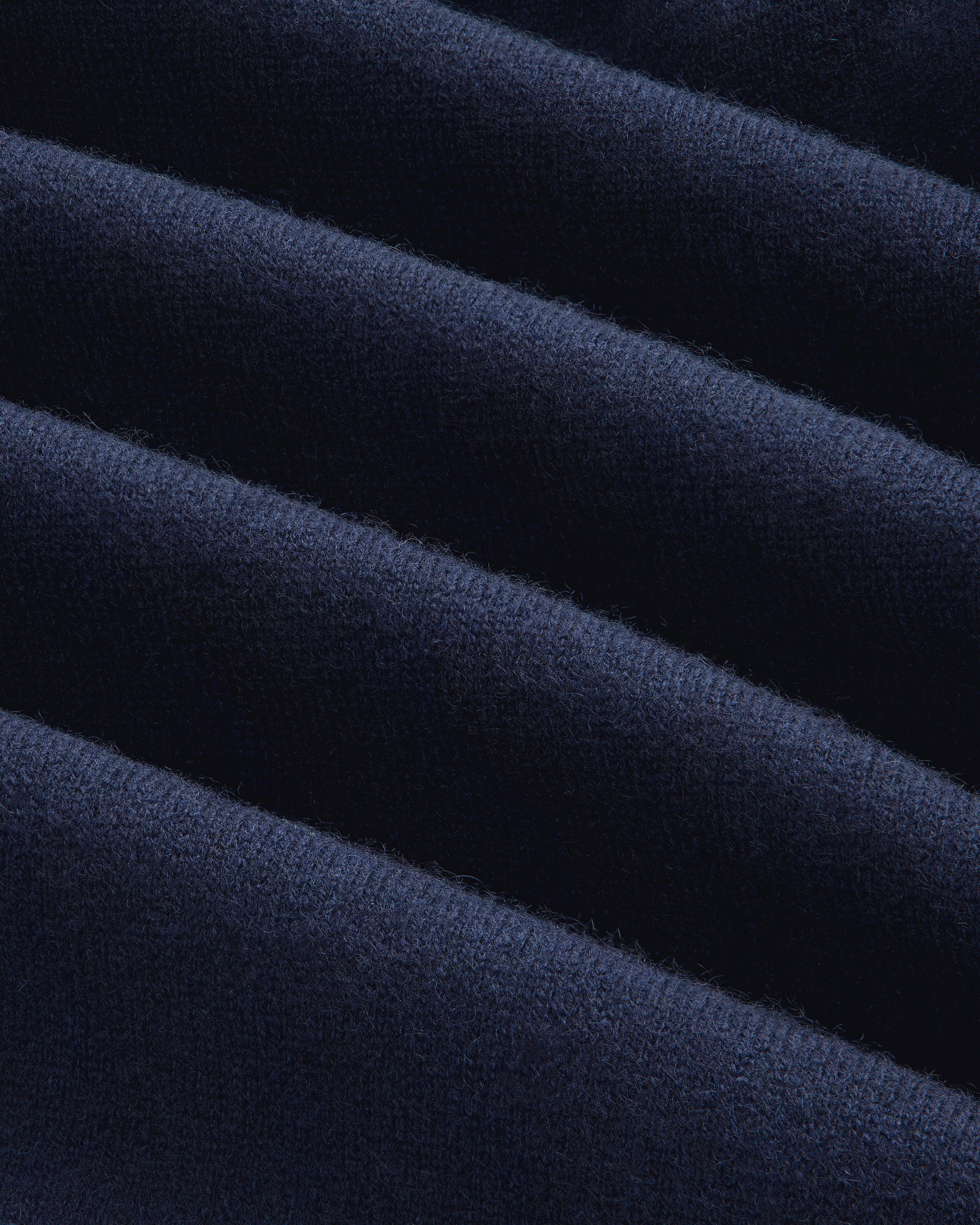 Close-up of dark blue, ribbed cashmere from the Full-Zip Pavilion Hoodie, showing its soft, textured surface.