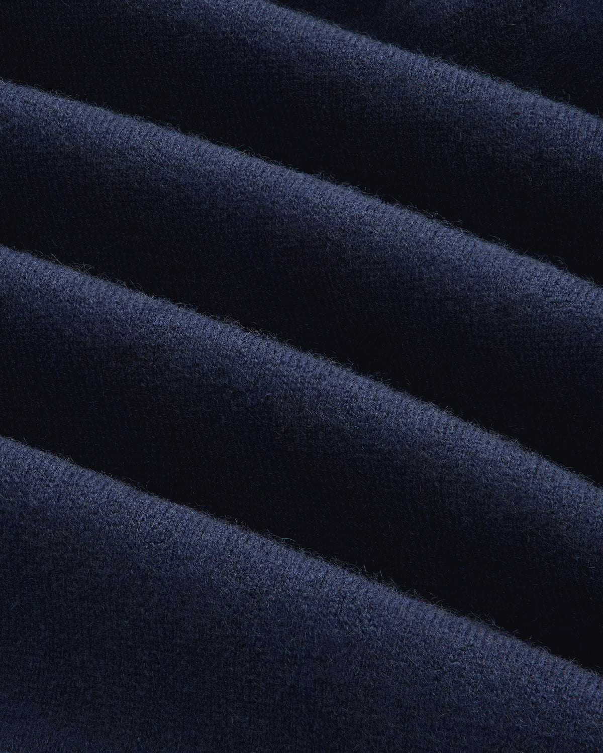 Close-up of Pavilion Cashmere Sweatpant in dark blue, ribbed and velvety with soft texture and wavy lines.