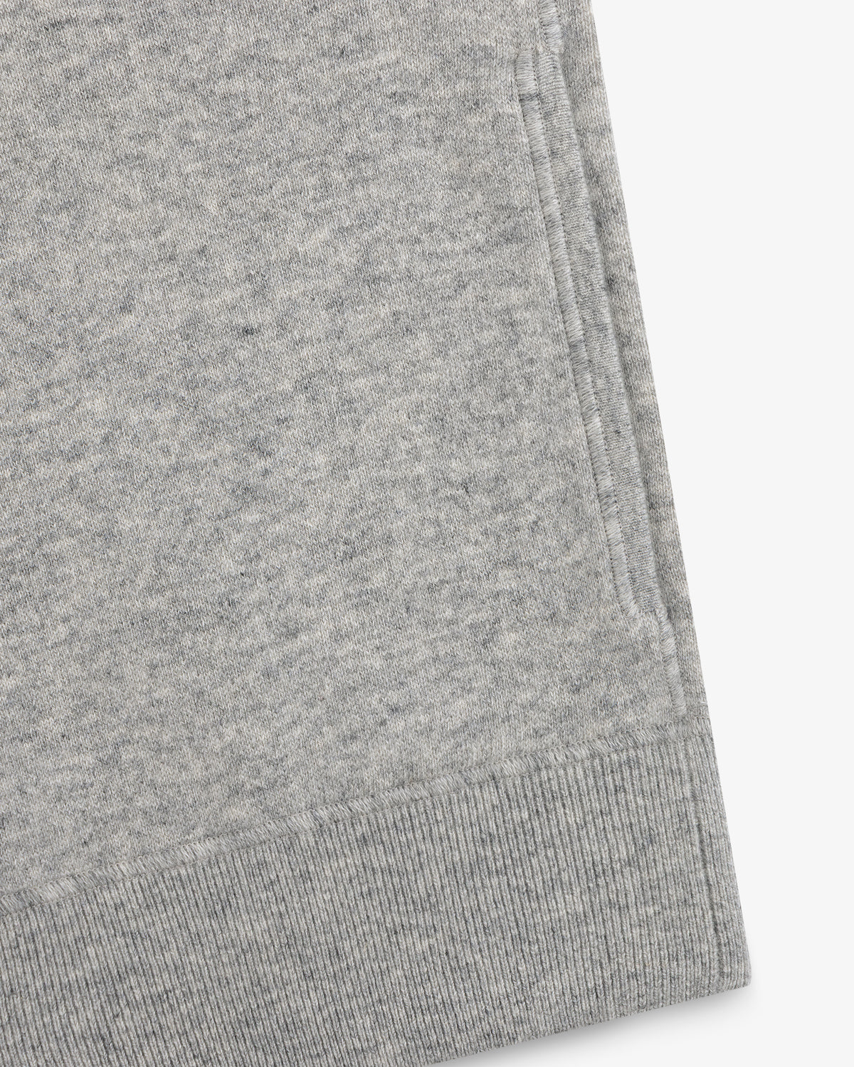 Close-up of a Quarter Zip Pavilion Cashmere Pullover hem and pocket in light gray on a white background.