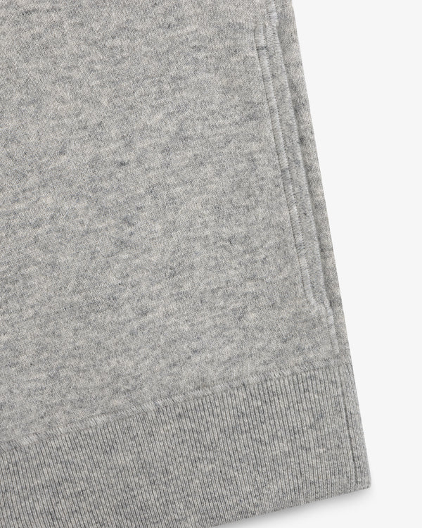 Close-up of a Quarter Zip Pavilion Cashmere Pullover hem and pocket in light gray on a white background.