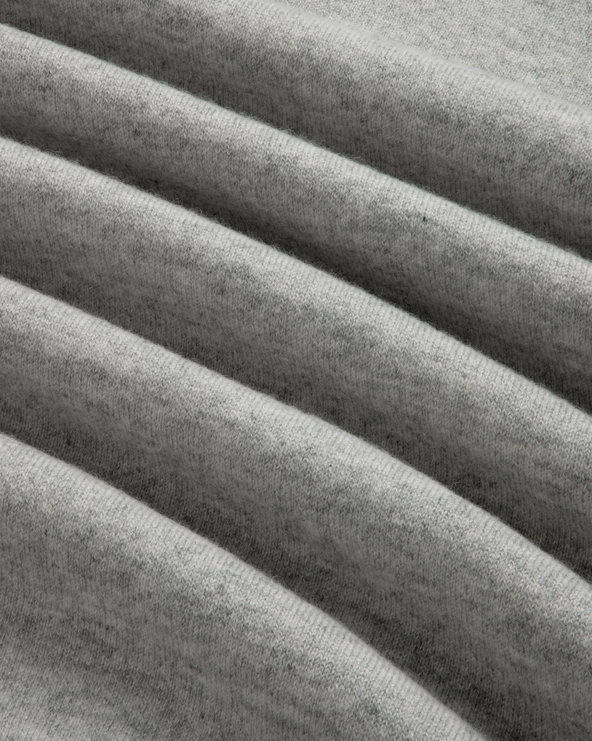 Close-up of grey, ribbed fabric on the Quarter Zip Pavilion Cashmere Pullover, showing its soft, textured pattern.