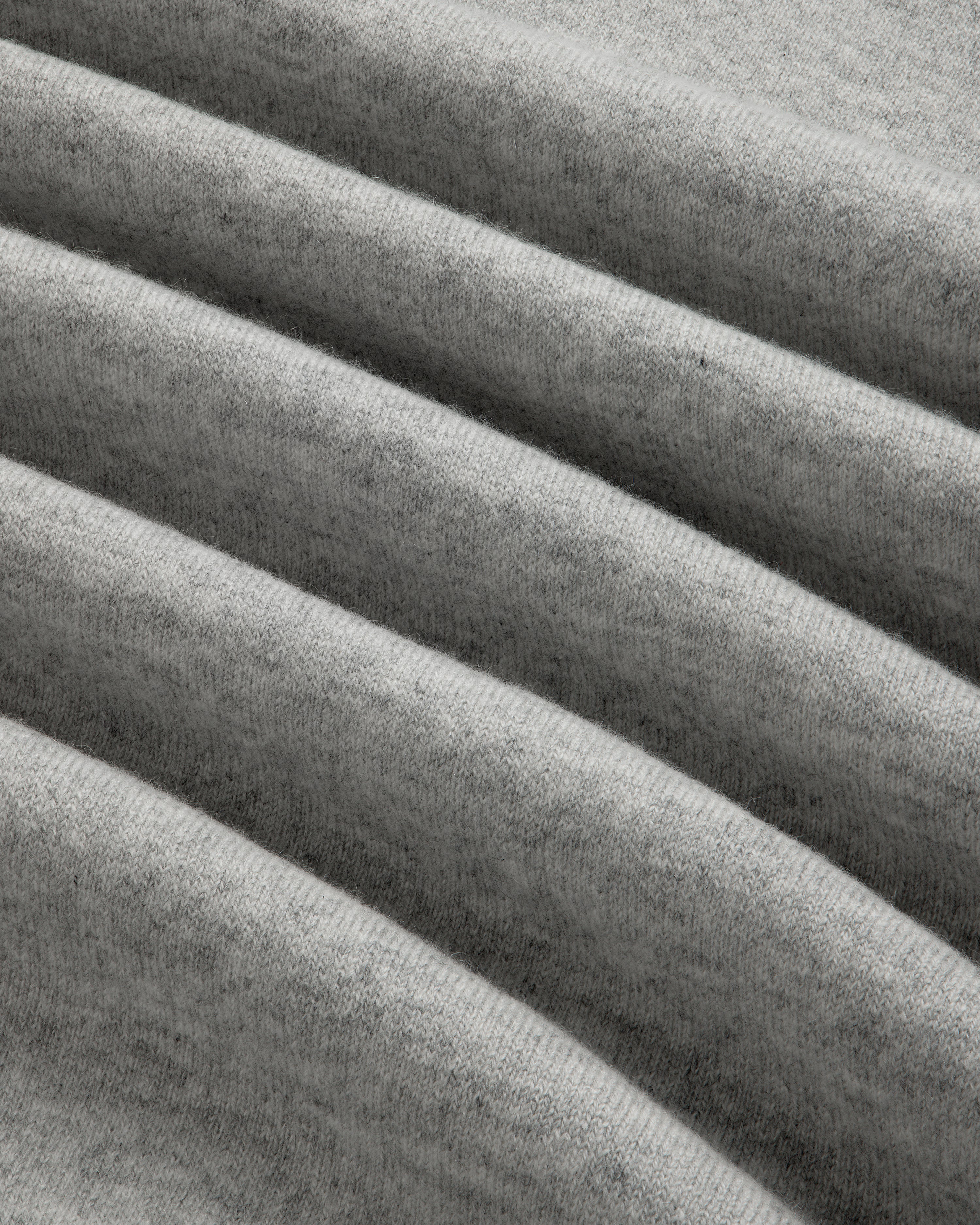 Close-up of grey, ribbed fabric on the Quarter Zip Pavilion Cashmere Pullover, showing its soft, textured pattern.