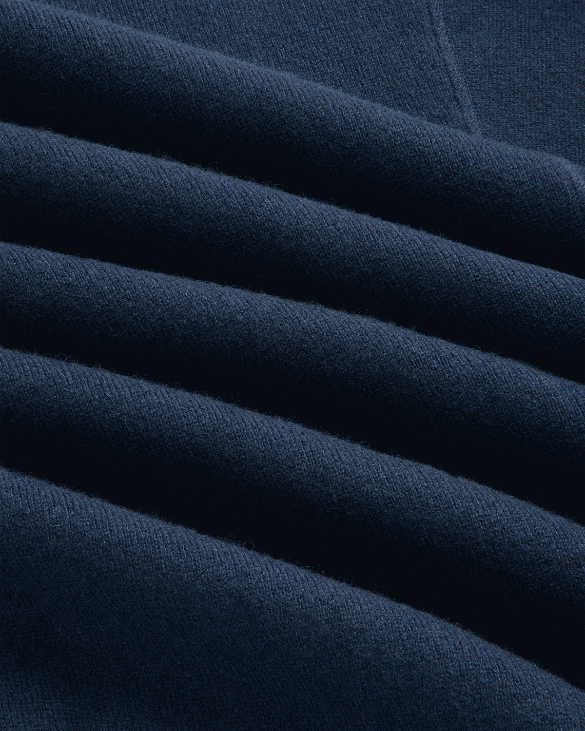 Close-up of the Quarter Zip Pavilion Cashmere Pullover in dark blue, highlighting its soft texture and neat creases.