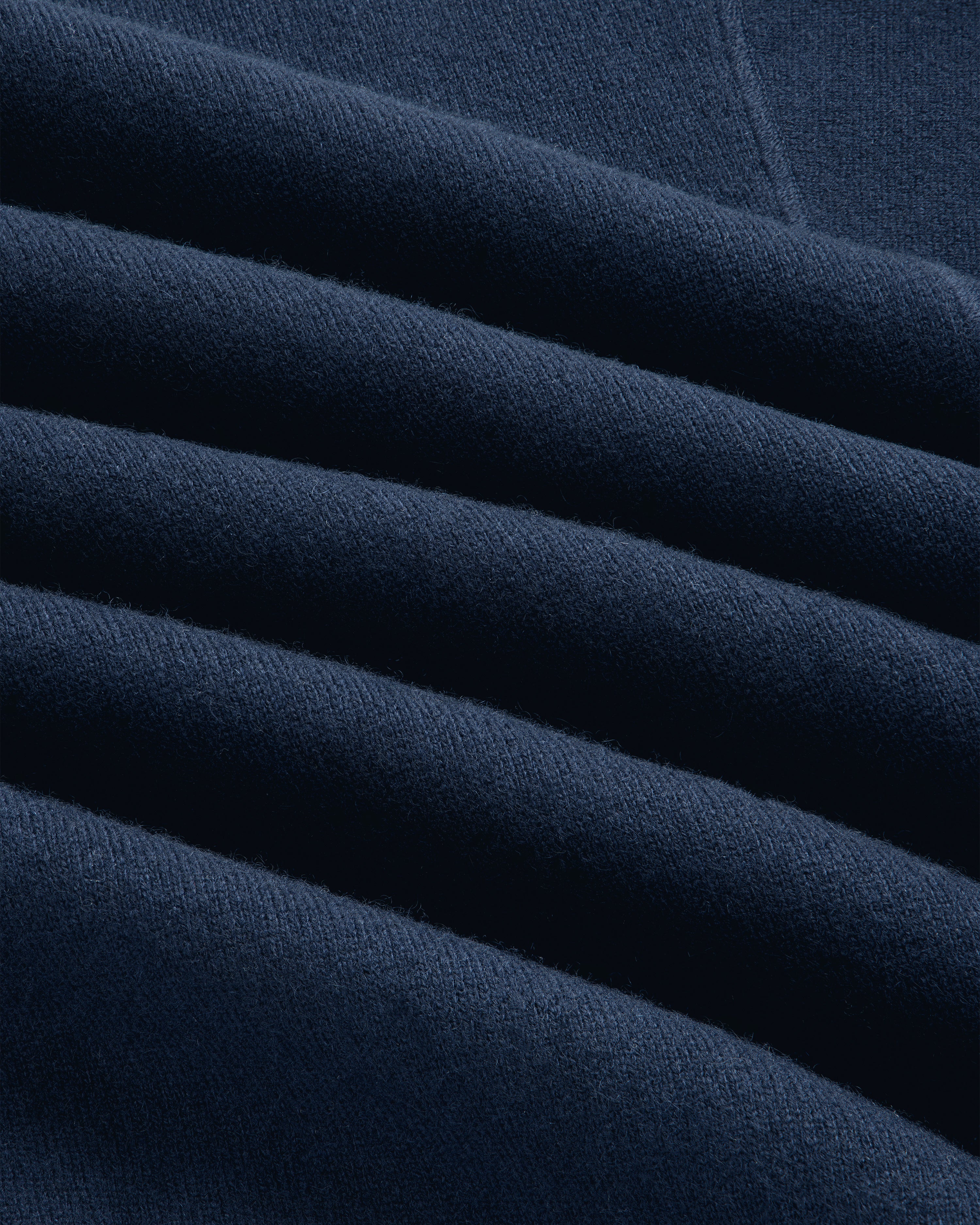 Close-up of the Quarter Zip Pavilion Cashmere Pullover in dark blue, highlighting its soft texture and neat creases.